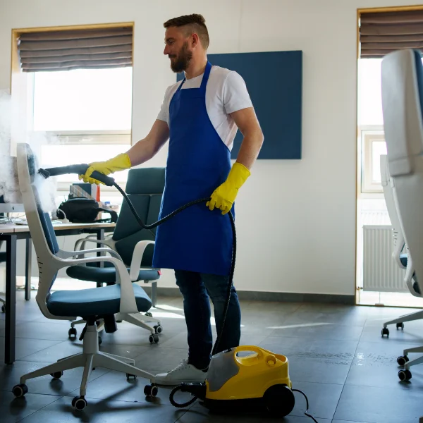 Homme portant un tablier bleu, représentant le service d’entretien ménager commercial.